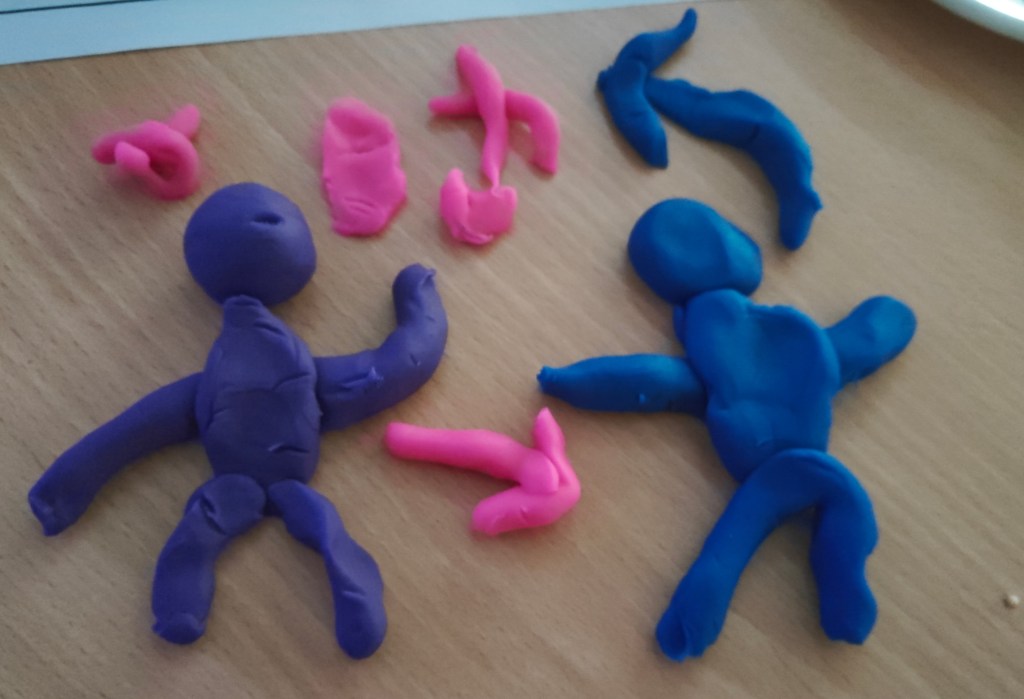A playdoh model. 2 figures, with arrows going between them